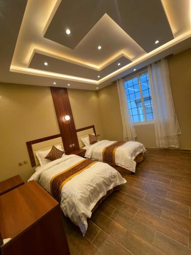 two beds in a bedroom with a coffered ceiling at شالية خاص in Khamis Mushayt