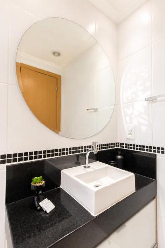 a bathroom with a white sink and a mirror at Noble Studio 22209, Piscina, Vaga, Academia, Ar in Guarulhos