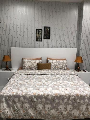 a bedroom with a large bed with two night stands at 1 Bed Apartment in Murree in Murree