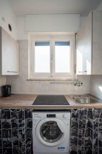 a kitchen with a washing machine and a sink at oasi relax Jacuzzi ultimo piano in Turin