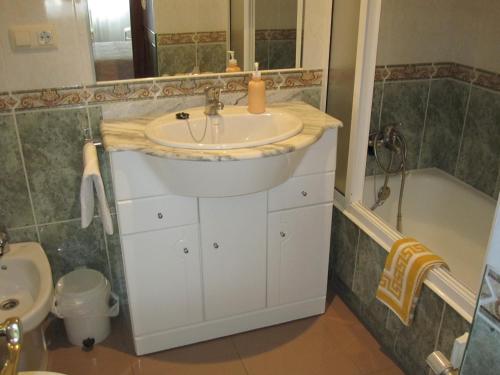 a bathroom with a sink and a bath tub at Pensión Chiquilla in O Grove