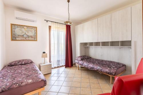 a bedroom with two beds and a window at Casa Konny in Gonnostramatza