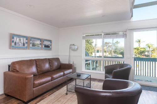a living room with a leather couch and two chairs at Seaside Retreat at Solimar Sands in Carpinteria