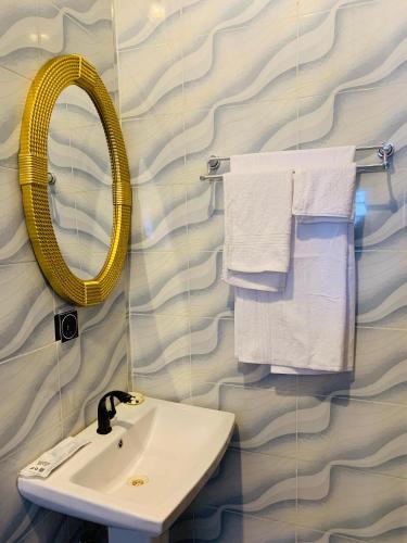 a bathroom with a sink and a mirror and towels at ACCENT HOMES Apartment in Asaba