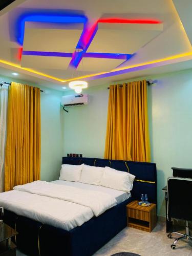 a bedroom with a bed with a blue and red ceiling at ACCENT HOMES Apartment in Asaba