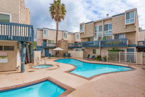 a swimming pool in front of a building with a palm tree at Sandbox at Solimar Sands in Carpinteria