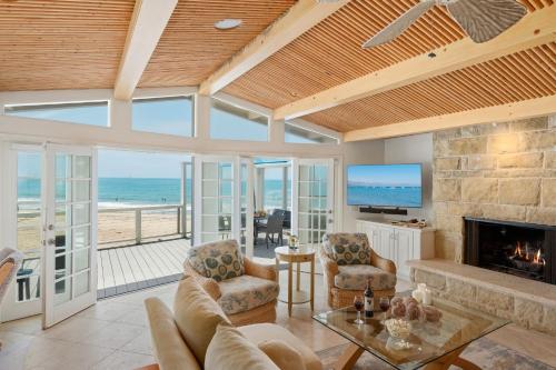 a living room with a fireplace and a view of the ocean at Padaro Sands in Carpinteria