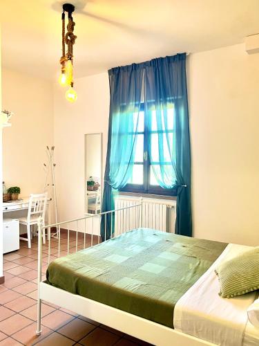 a bedroom with a bed and a blue curtain at Podere al Fico B&B in Cecina