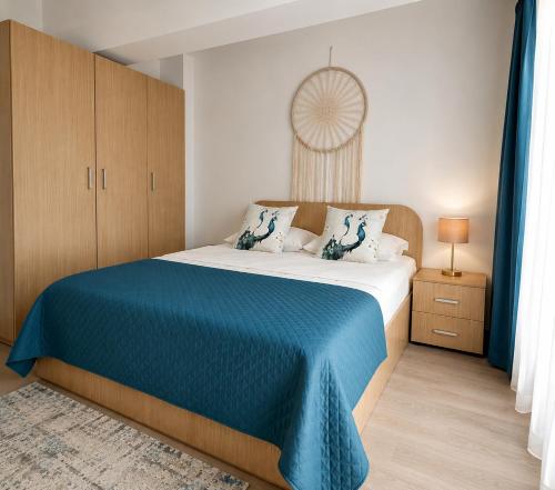 a bedroom with a large bed with a blue blanket at Fly Airport Residences & Therme-SELF CHECK-IN in Otopeni