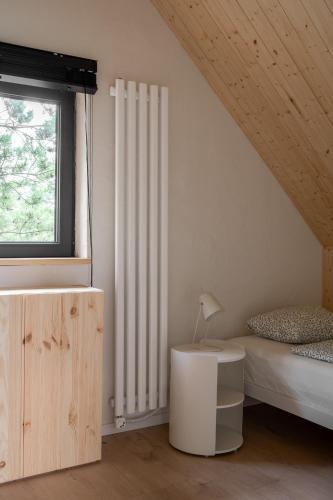 a bedroom with a bed and a white radiator at Lobeliowe Domki in Chośnica