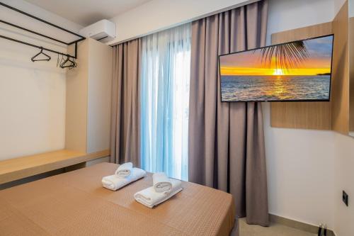 a hotel room with a tv on the wall at Sunrise suites in Kallithea Halkidikis