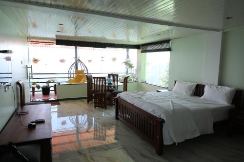 a bedroom with a large bed and a dining room at KarSa Woods, Kodaikanal in Perumālmalai
