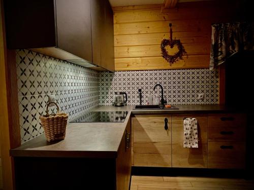 a kitchen with wooden cabinets and a counter top at Wypas Hills - domek na wyłączność in Białka Tatrzańska