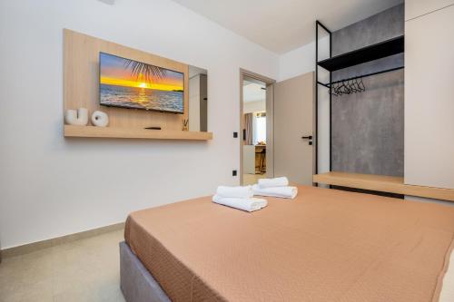 a bedroom with a bed with two towels on it at Sunrise suites in Kallithea Halkidikis