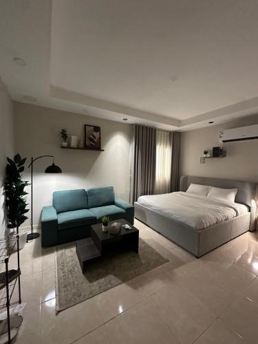 a bedroom with a bed and a blue couch at Clarance studio in Dhahran