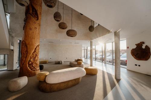 a living room with a couch and a tree at Hotel Narcisa in Veržej