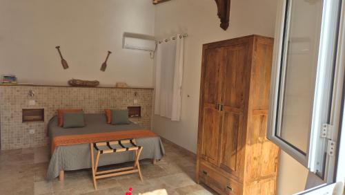 a bedroom with a bed and a wooden cabinet at Chez didine in Terre-de-Haut