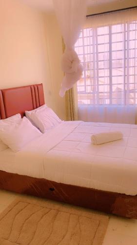 a bedroom with a bed with a teddy bear on it at Moh airbnbs in Kisumu