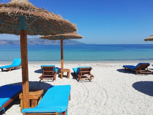 a group of chairs and umbrellas on a beach at Orikum beach in Orikum