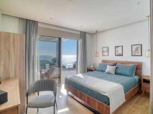 a bedroom with a bed and a view of the ocean at Villa Elusia in Kefalos