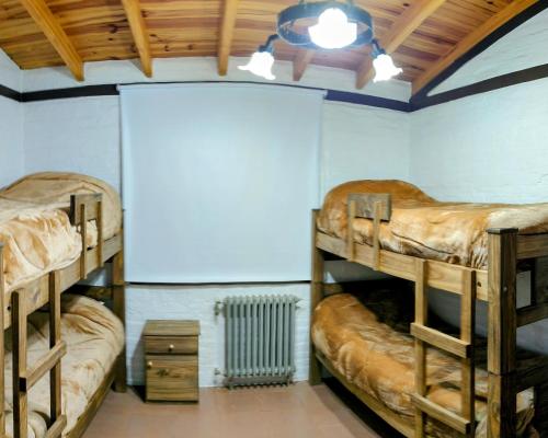 a room with three bunk beds and a radiator at Ayün Mawida in Las Compuertas