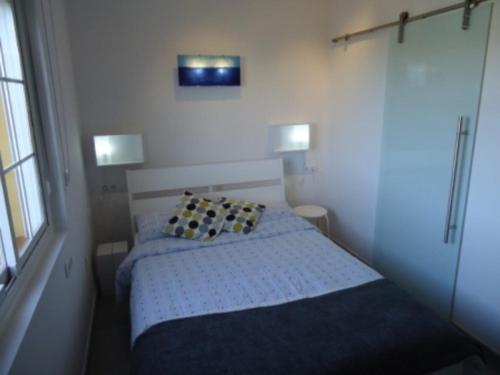 1 dormitorio pequeño con 1 cama y 2 lámparas en Livingtarifa La Tortuguita en Tarifa