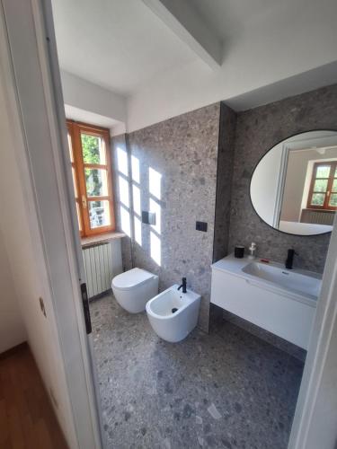 a bathroom with two sinks and a tub and a mirror at Mulimù - Guesthouse in Montecalvo Versiggia