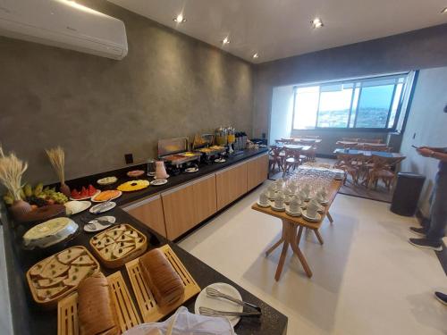 a restaurant with a table with food on it at V-Home Flat Hotel in Macaé