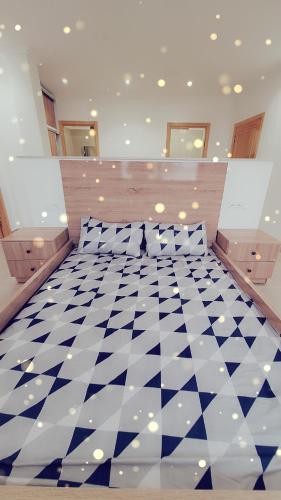 a bedroom with a checkered floor with two pillows at Suite Ania in Imejoudene