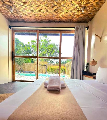 a bedroom with a bed and a large window at Wadi Residence in General Luna