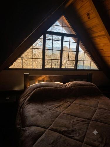 a bed in a room with a large window at Ayün Mawida in Las Compuertas