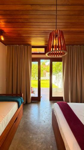 a bedroom with two beds and a chandelier at Bossa Atins in Atins
