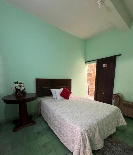 a bedroom with a bed and a table in it at Hotel Puerta de Jade in Ciudad Valles