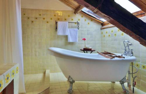 uma casa de banho com uma grande banheira branca num quarto em Hotel Casavieja em San Cristóbal de Las Casas