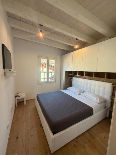 a bedroom with a large bed and a television at Rovetta Tre Piazze Apartments in Brescia