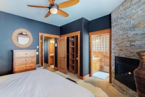 a bedroom with a ceiling fan and a fireplace at Tree Tops 15 in Big White