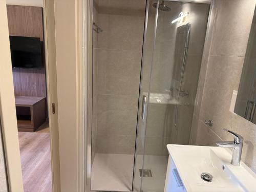 una doccia con porta in vetro accanto a un lavandino e un bagno di Pine Inn a Spilia