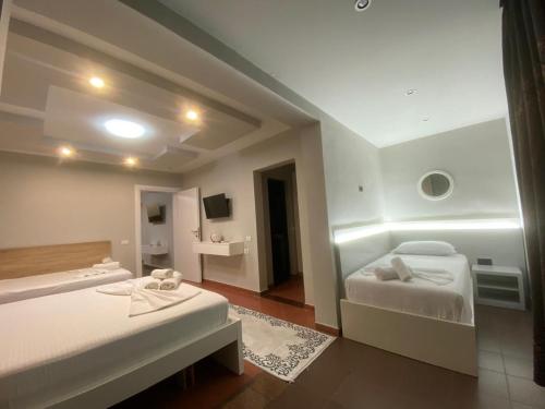 a hotel room with two beds and a bathroom at Luander Hotel in Tirana