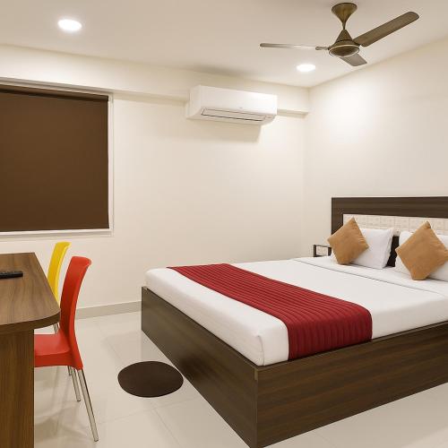 a bedroom with a bed and a desk and a tv at Sg Happy Stay in Machilīpatnam