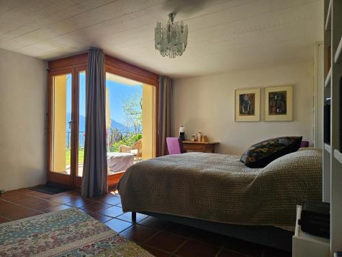 a bedroom with a bed and a sliding glass door at Casa Conte in Orselina