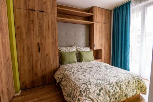 a bedroom with a bed with a wooden wall at Apartament 24 in Mysłowice
