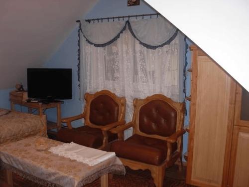 a living room with two chairs and a window at Agroturystyka u Jasienka in Mrukowa