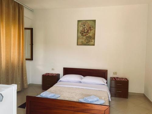 a bedroom with a bed with two nightstands and a picture at Olive Nest Bunec in Sasaj