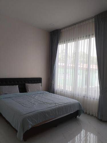 ein Schlafzimmer mit einem Bett und einem großen Fenster in der Unterkunft TamApartment in Ko Phangan