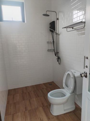 ein weißes Badezimmer mit Toilette und Fenster in der Unterkunft TamApartment in Ko Phangan