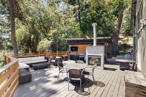 a deck with a table and chairs and a fireplace at The Polished Pine in Crestline