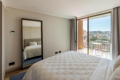 a bedroom with a bed and a large mirror at The Downtown Largo do Carmo in Faro