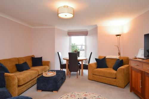a living room with two couches and a table at Lochview at 33a in Gourock