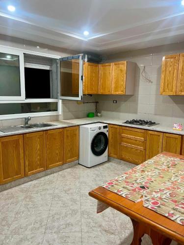 a kitchen with wooden cabinets and a washing machine at Dar Meriem in Korba