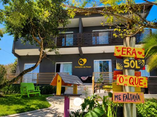 a building with a sign in front of it at Pousada Coração do Rosa - Praia do Rosa/SC in Praia do Rosa